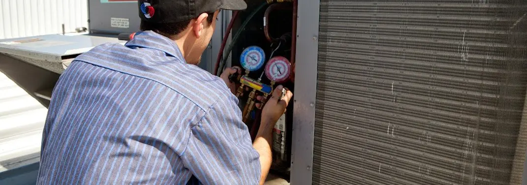 HVAC technician servicing a condenser unit in Tifton