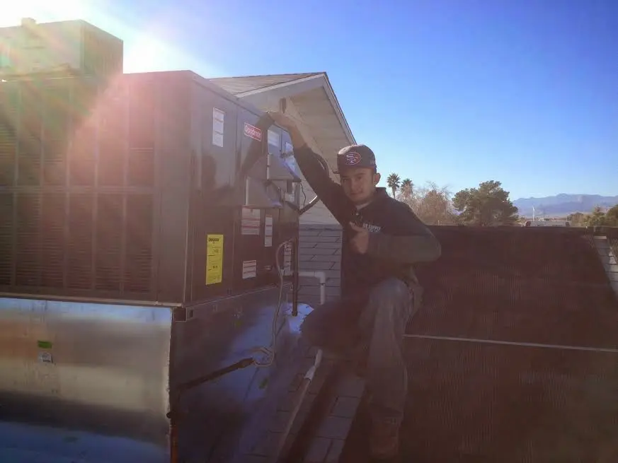 HVAC technician performing Boiler Repair on a rooftop unit in Tifton